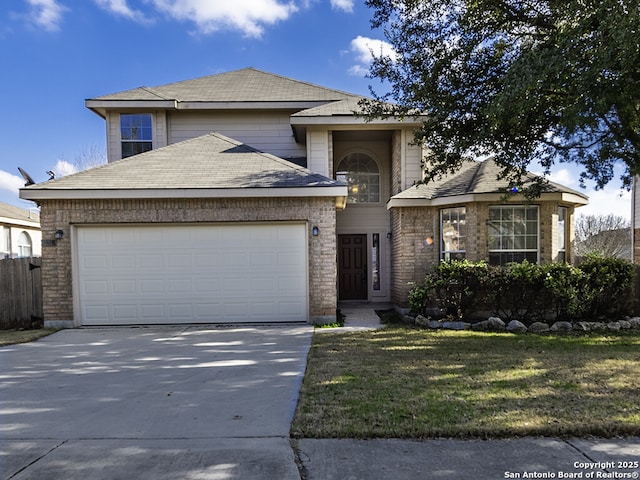 traditional-style home featuring an attached garage, driveway, and a front yard