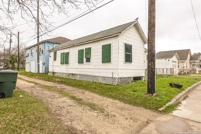 view of side of property featuring driveway and a yard