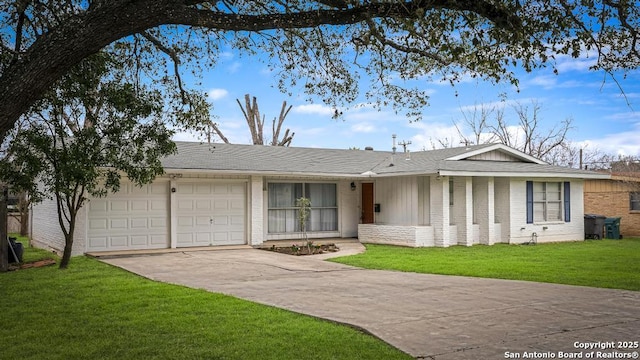 ranch-style home with an attached garage, brick siding, concrete driveway, and a front yard