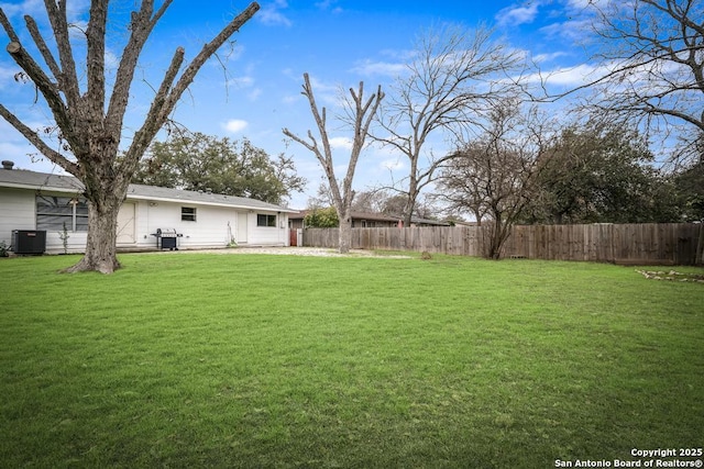 view of yard featuring fence and central air condition unit