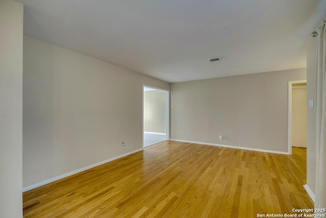 unfurnished room featuring light wood-style flooring and baseboards