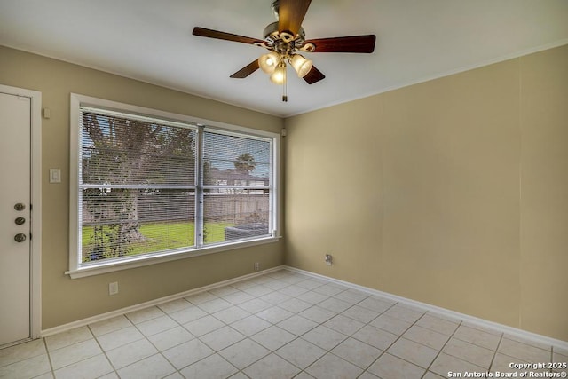 empty room with light tile patterned floors, ceiling fan, and baseboards