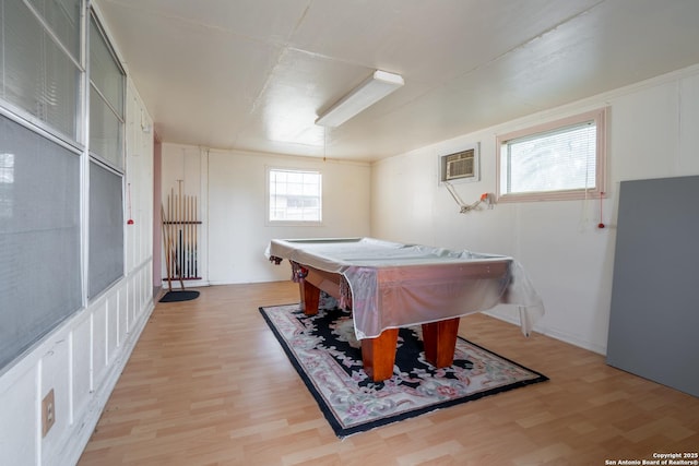 recreation room with light wood-style floors, an AC wall unit, and billiards