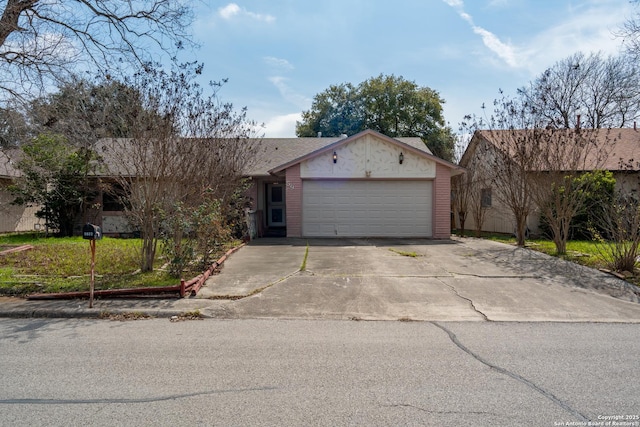 view of front of home with a garage, brick siding, and driveway