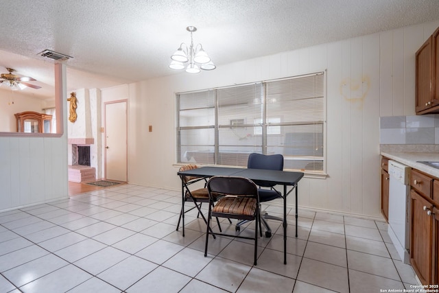 dining space featuring light tile patterned floors, visible vents, a textured ceiling, and ceiling fan with notable chandelier