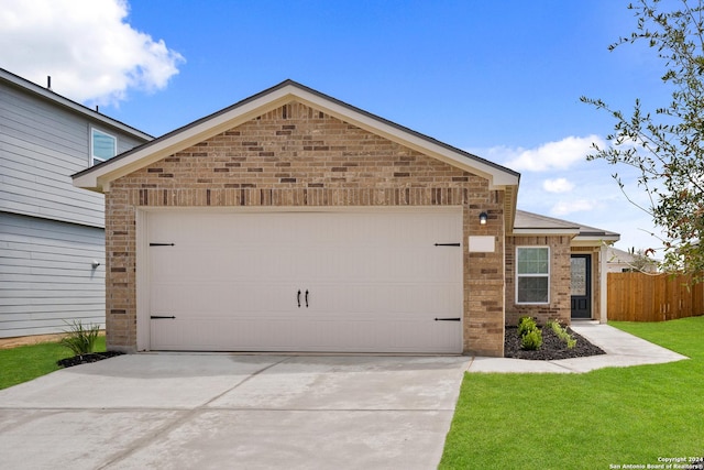 view of front of house featuring brick siding, an attached garage, a front yard, fence, and driveway