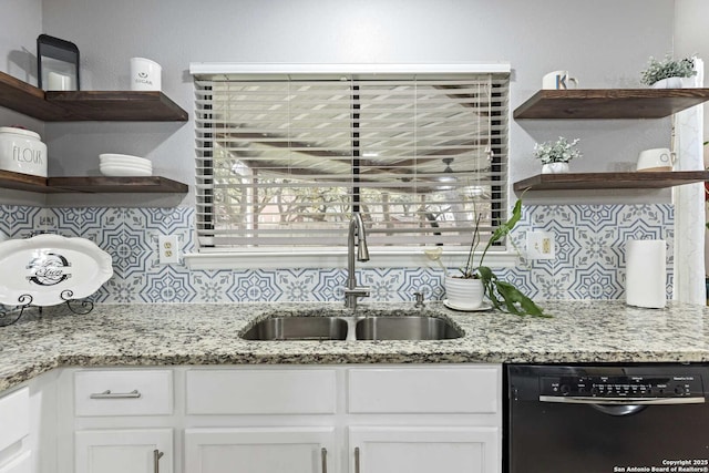 kitchen featuring dishwasher, light stone countertops, white cabinetry, open shelves, and a sink