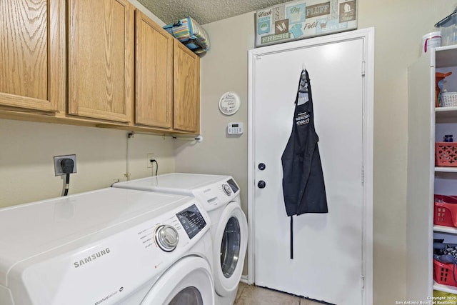 washroom with cabinet space, a textured ceiling, and separate washer and dryer