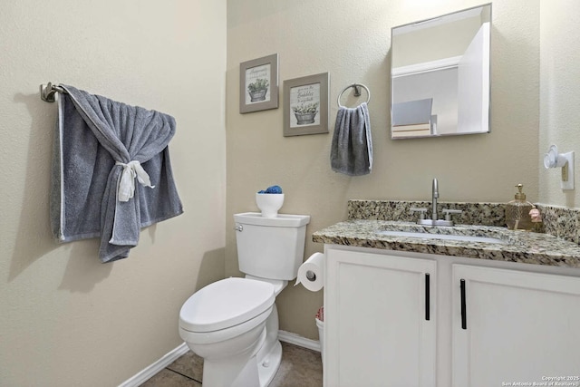 bathroom featuring toilet, tile patterned flooring, baseboards, and vanity