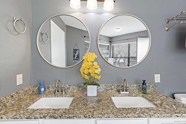 bathroom with a sink and double vanity