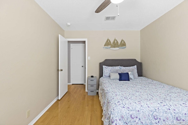 bedroom featuring ceiling fan, light wood-type flooring, visible vents, and baseboards