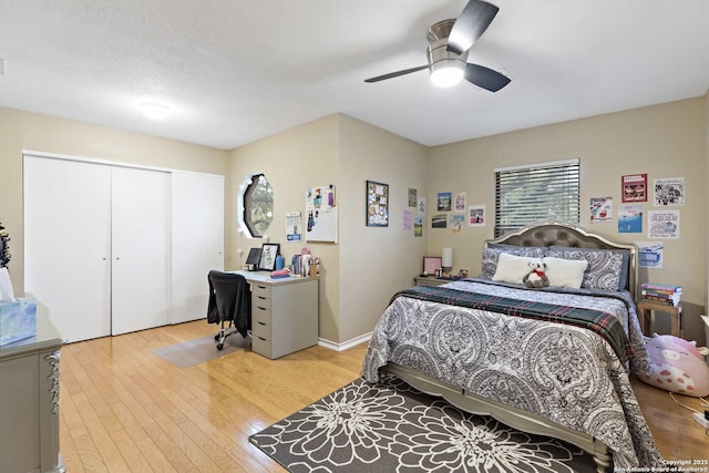 bedroom with light wood-style floors, a closet, baseboards, and a ceiling fan