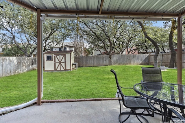 view of yard with outdoor dining area, a patio, a shed, a fenced backyard, and an outdoor structure