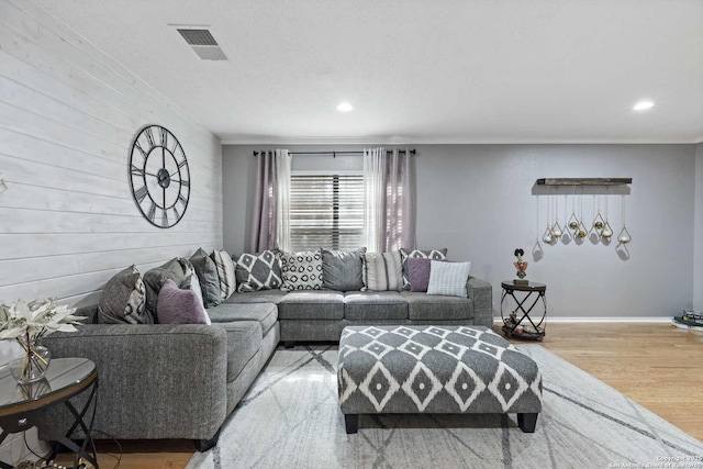 living room featuring light wood-type flooring, baseboards, visible vents, and recessed lighting