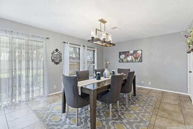 tiled dining space with visible vents, a notable chandelier, and baseboards