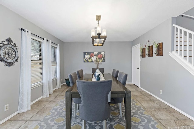 tiled dining room with a notable chandelier, stairway, and baseboards