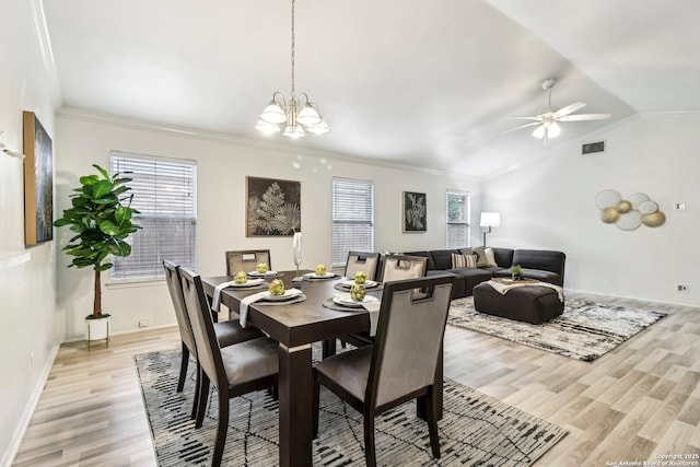 dining area with lofted ceiling, light wood-type flooring, visible vents, and crown molding