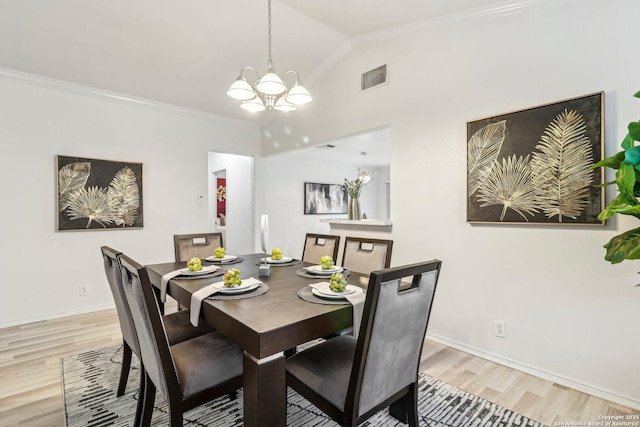 dining room featuring visible vents, light wood-style floors, vaulted ceiling, an inviting chandelier, and crown molding