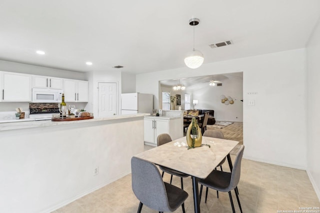 dining space featuring baseboards, a chandelier, visible vents, and recessed lighting