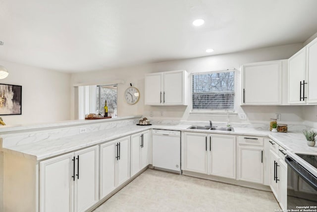 kitchen with dishwasher, a peninsula, a sink, and white cabinets