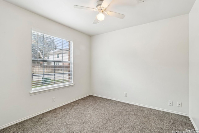 carpeted empty room with ceiling fan and baseboards