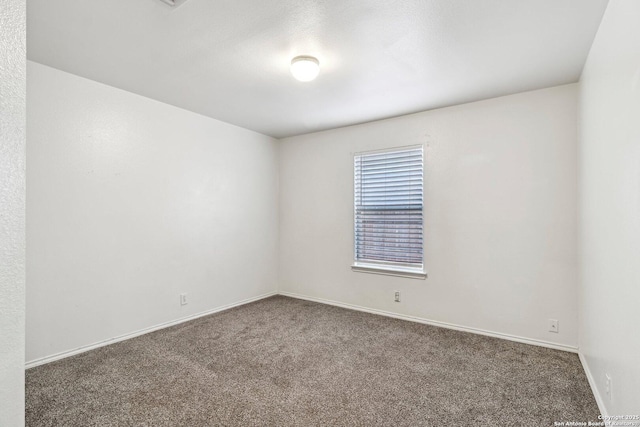 carpeted empty room featuring baseboards