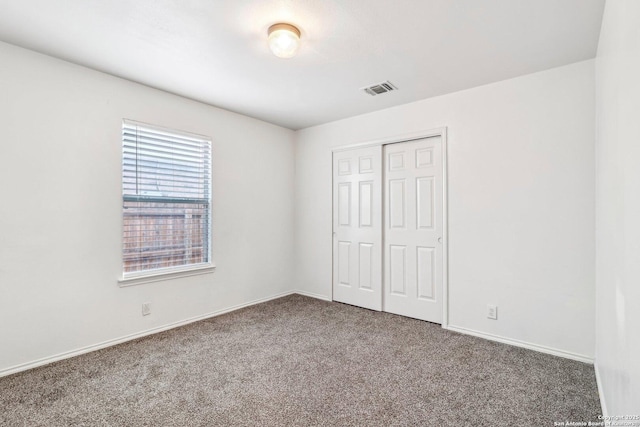 unfurnished bedroom featuring carpet, a closet, visible vents, and baseboards