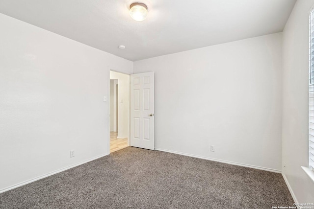 empty room with baseboards and carpet flooring