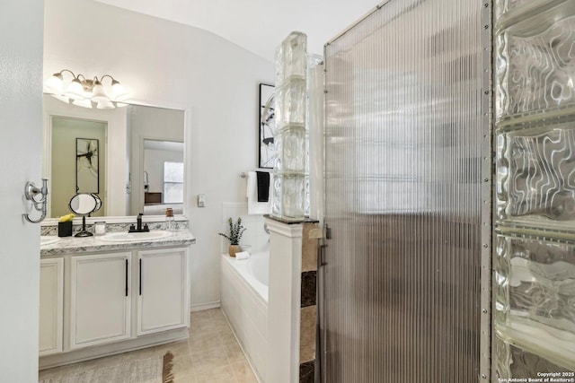 bathroom featuring tile patterned flooring, vaulted ceiling, vanity, and a bath