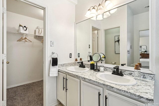 full bathroom featuring a spacious closet, double vanity, a sink, and visible vents