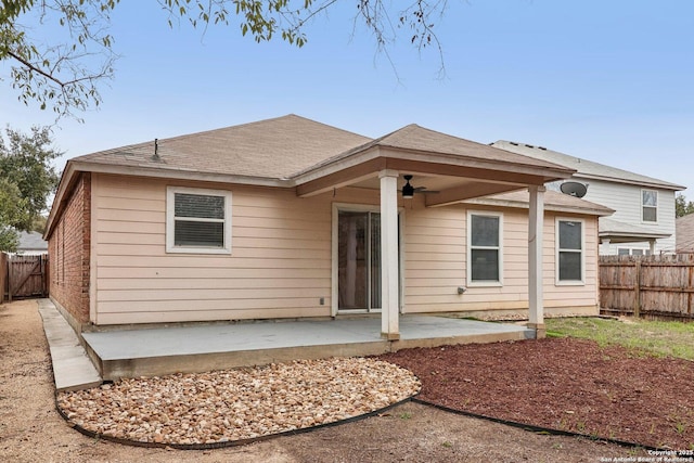 rear view of house featuring roof with shingles, a patio area, and fence