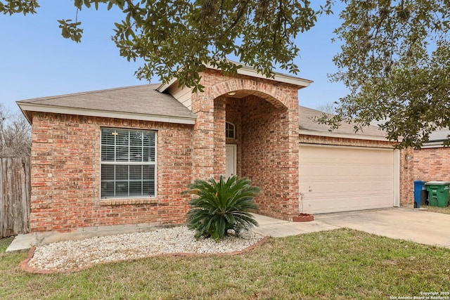 traditional-style home featuring driveway, roof with shingles, an attached garage, a front lawn, and brick siding