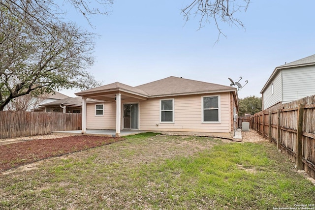 back of house with a yard, a fenced backyard, a patio, and central air condition unit