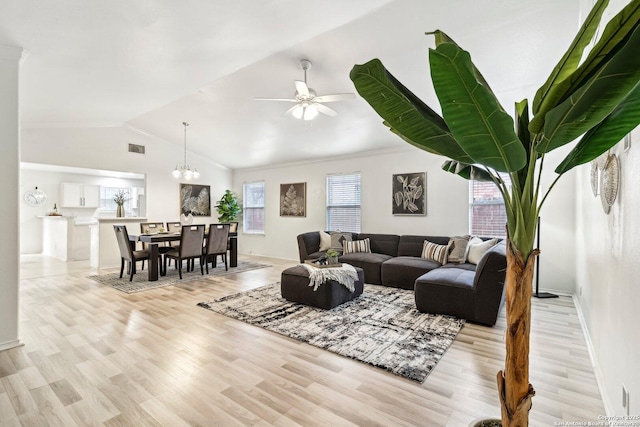 living room with visible vents, ornamental molding, vaulted ceiling, light wood-type flooring, and ceiling fan with notable chandelier