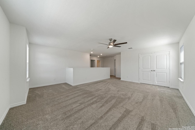 spare room with carpet floors, ceiling fan, and baseboards