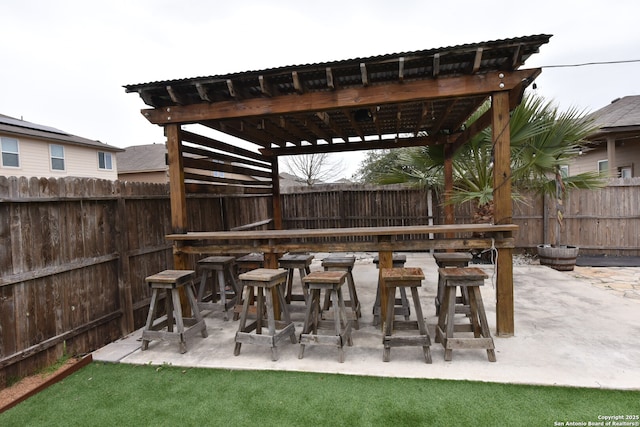 view of patio / terrace featuring outdoor dry bar, fence, and a pergola