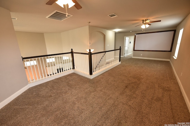 empty room featuring a ceiling fan, carpet, visible vents, and baseboards