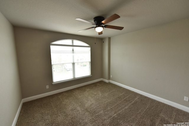 carpeted spare room with ceiling fan and baseboards