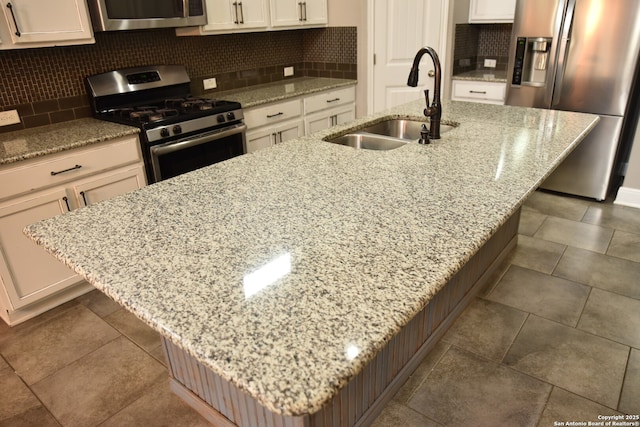 kitchen with appliances with stainless steel finishes, a kitchen island with sink, and a sink