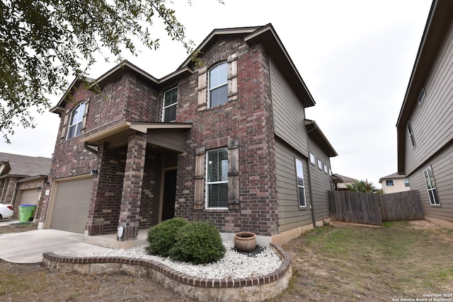 traditional-style home with driveway, brick siding, an attached garage, and fence