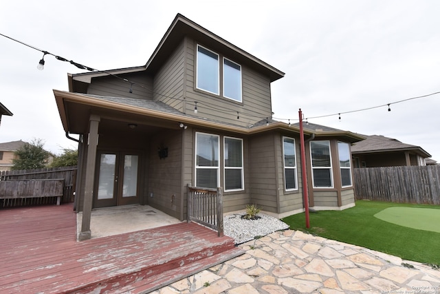 rear view of house with a patio area, fence, a deck, and french doors