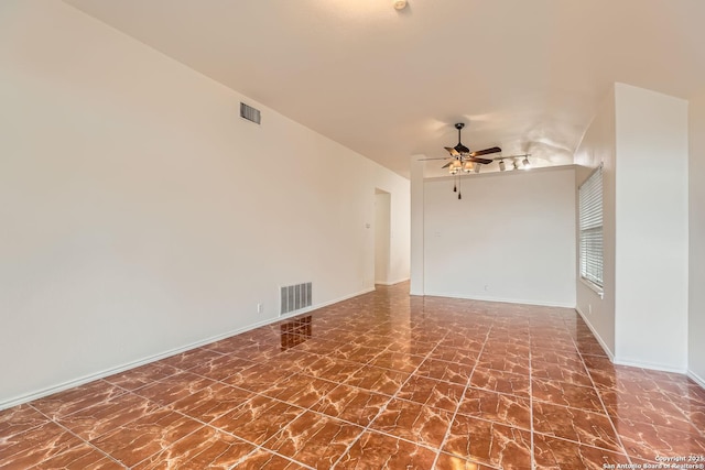 spare room with marble finish floor, ceiling fan, visible vents, and baseboards