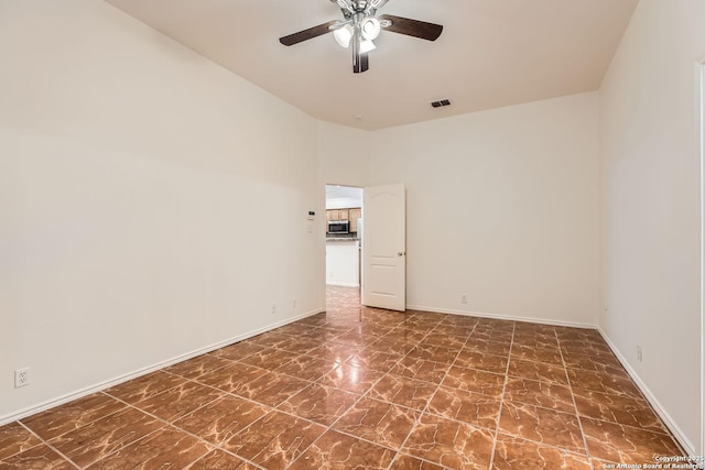 empty room with baseboards, visible vents, and a ceiling fan