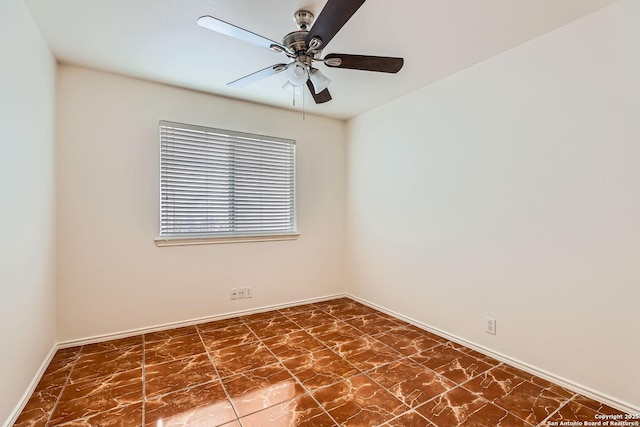 unfurnished room with a ceiling fan and baseboards