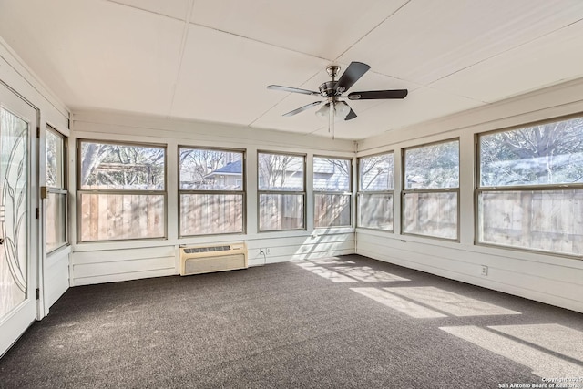 unfurnished sunroom with a ceiling fan and a wall mounted AC