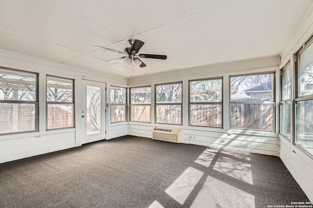 unfurnished sunroom featuring an AC wall unit and a ceiling fan