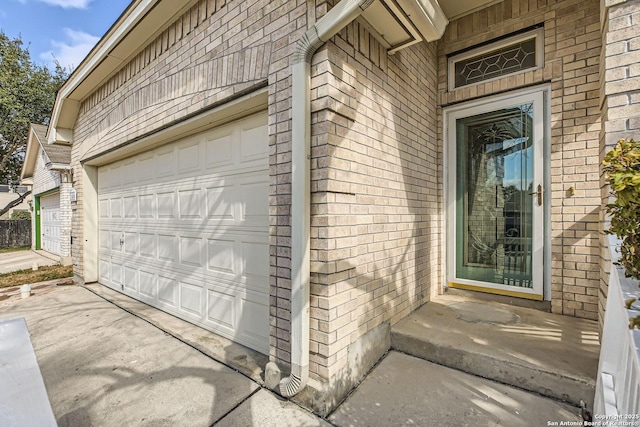 property entrance with driveway and brick siding