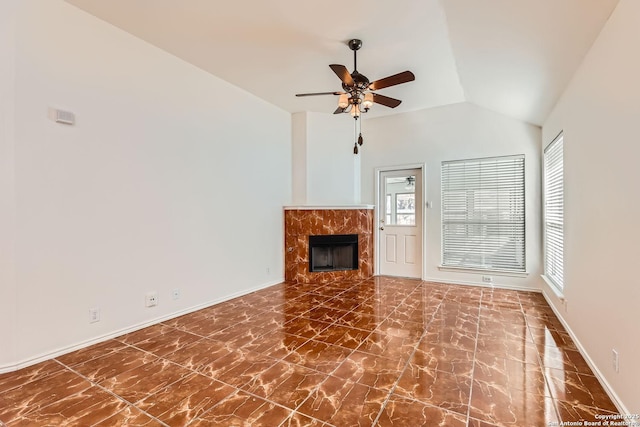 unfurnished living room with lofted ceiling, a fireplace, baseboards, and ceiling fan