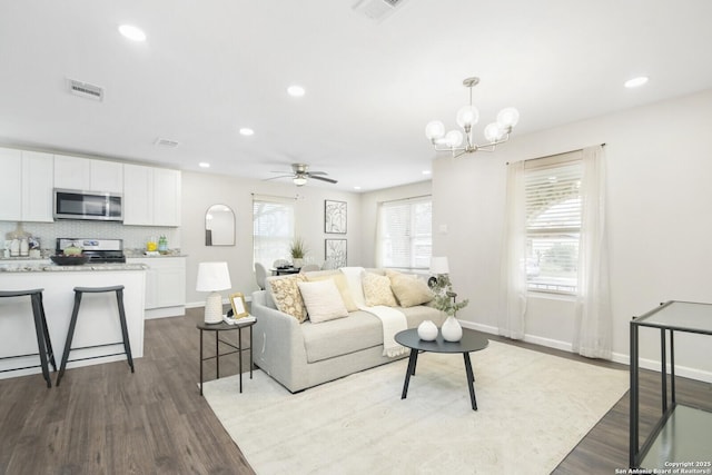 living room featuring light wood-type flooring, visible vents, and recessed lighting