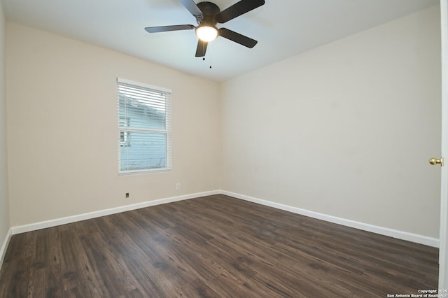 spare room featuring dark wood-type flooring, a ceiling fan, and baseboards